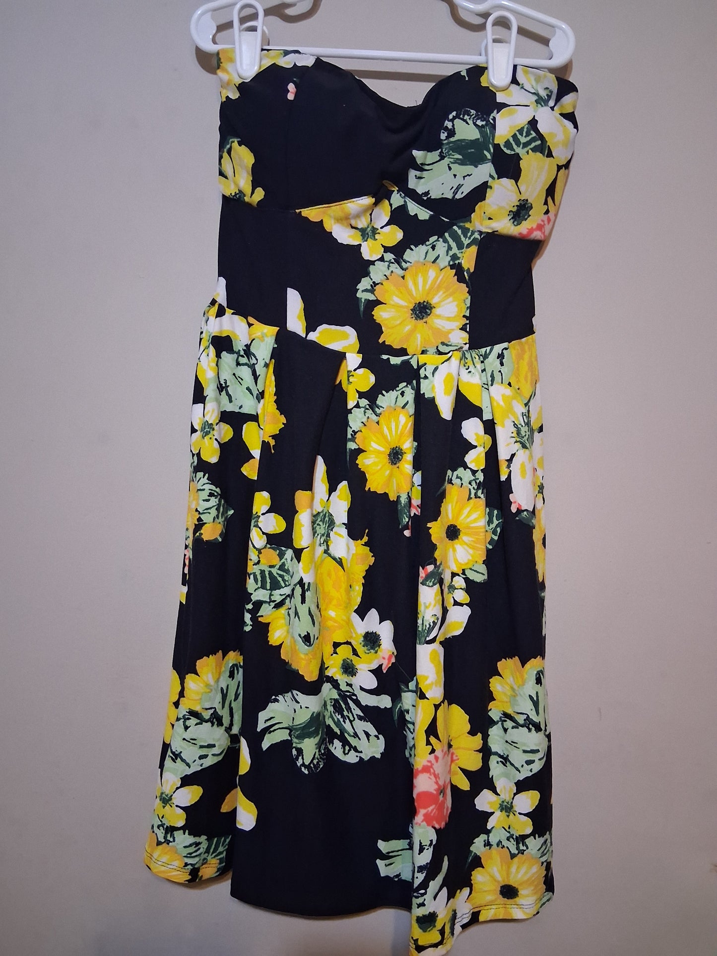 Floral Strapless Fit & Flare Dress showcased on a hanger, featuring vibrant yellow and green floral patterns on a black background.