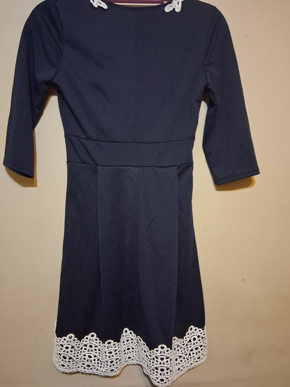 Navy & White Lace Accent Dress featuring intricate white lace detailing at the hem and elegant 3/4 sleeves.